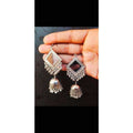Silver-toned oxidized earrings featuring central mirror work detail.