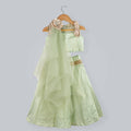 Girl wearing green zig-zag printed ghagra choli with gold lame frill strips and net dupatta.