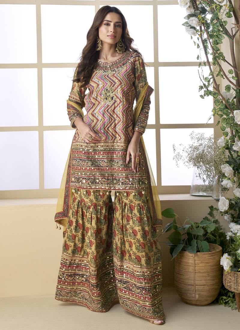 Woman wearing a beige crepe silk palazzo suit with digital print and Aari embroidery