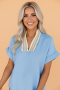 Women wearing a blue V-neck blouse with crochet lace trim and rolled short sleeves