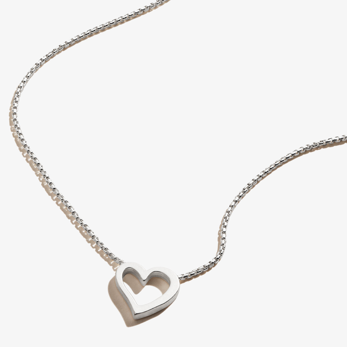 Minimalist heart-shaped pendant necklace in metallic silver and gold tones by Alex And Ani.