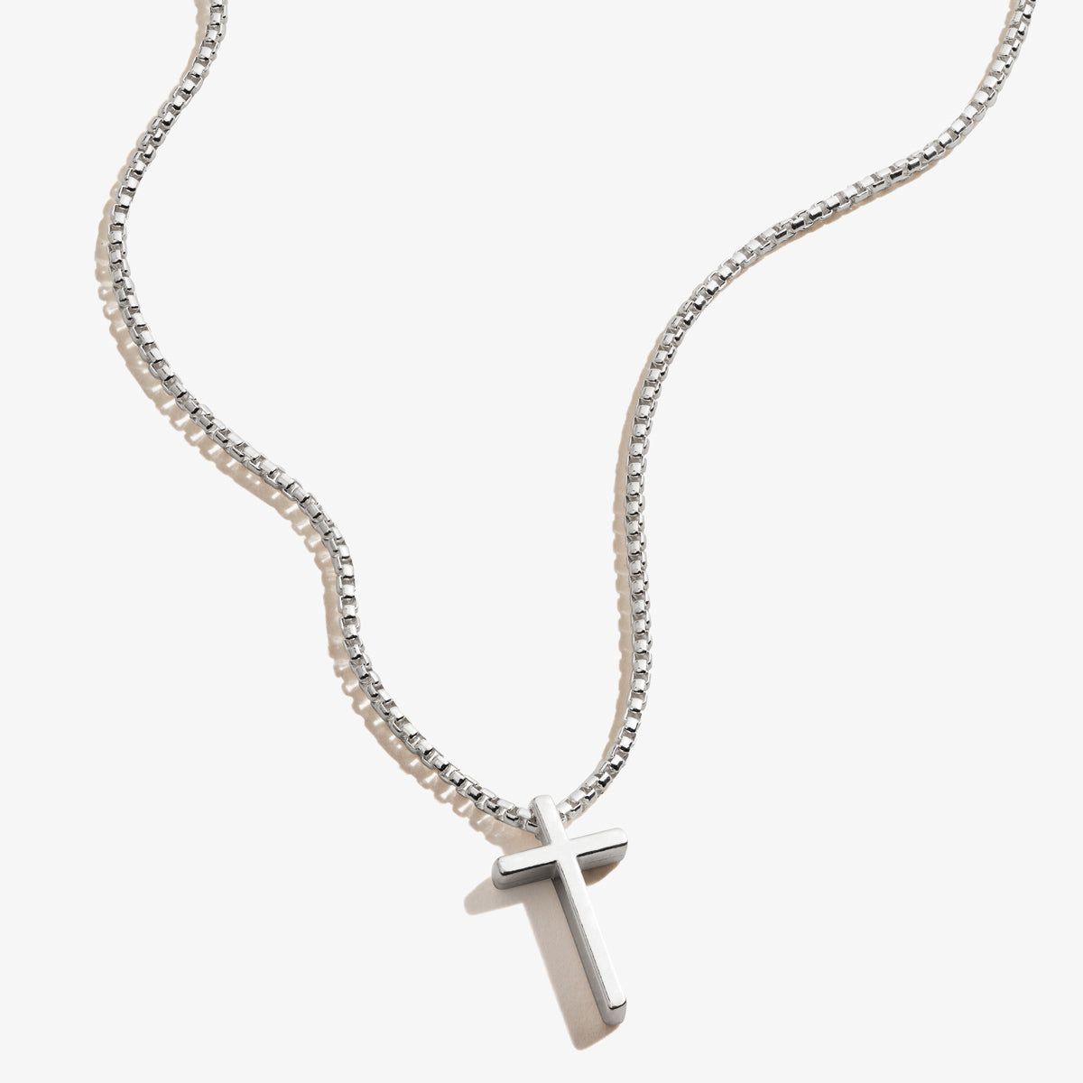 A dainty cross pendant necklace on an adjustable chain, available in sterling silver or 14k gold vermeil.