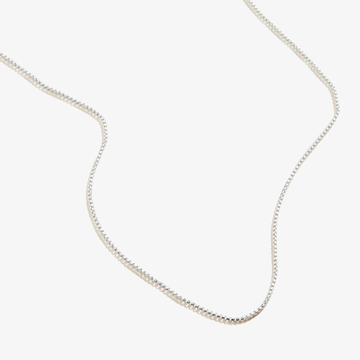 A classic, high-shine sterling silver chain necklace worn solo against a neutral background.