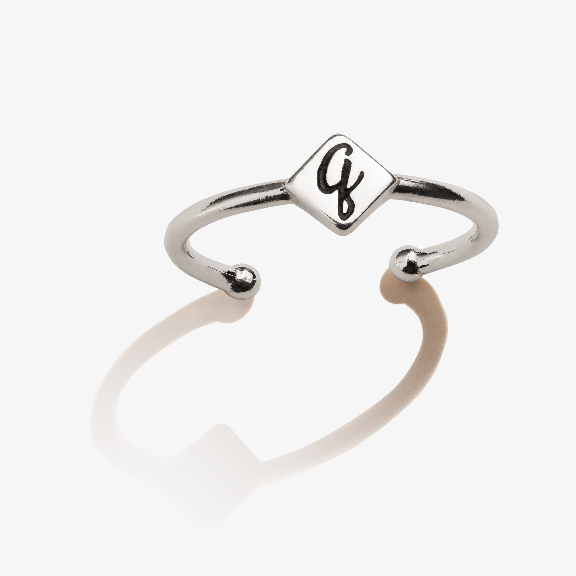 Close-up of an elegant Initial Q ring worn on a finger, showcasing minimalist design