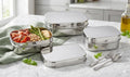 A set of three nesting stainless steel food containers with a minimalist design.