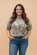 Woman wearing a brown, olive-green, and tan woodland camo short sleeve crew neck t-shirt with a relaxed fit