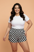 Women wearing black and white checkerboard print high-waisted athleisure shorts with side pockets.