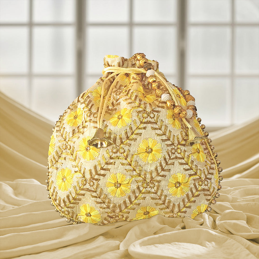 A handcrafted embroidered silk brocade potli bag featuring pearl borders and beaded handles for wedding occasions.