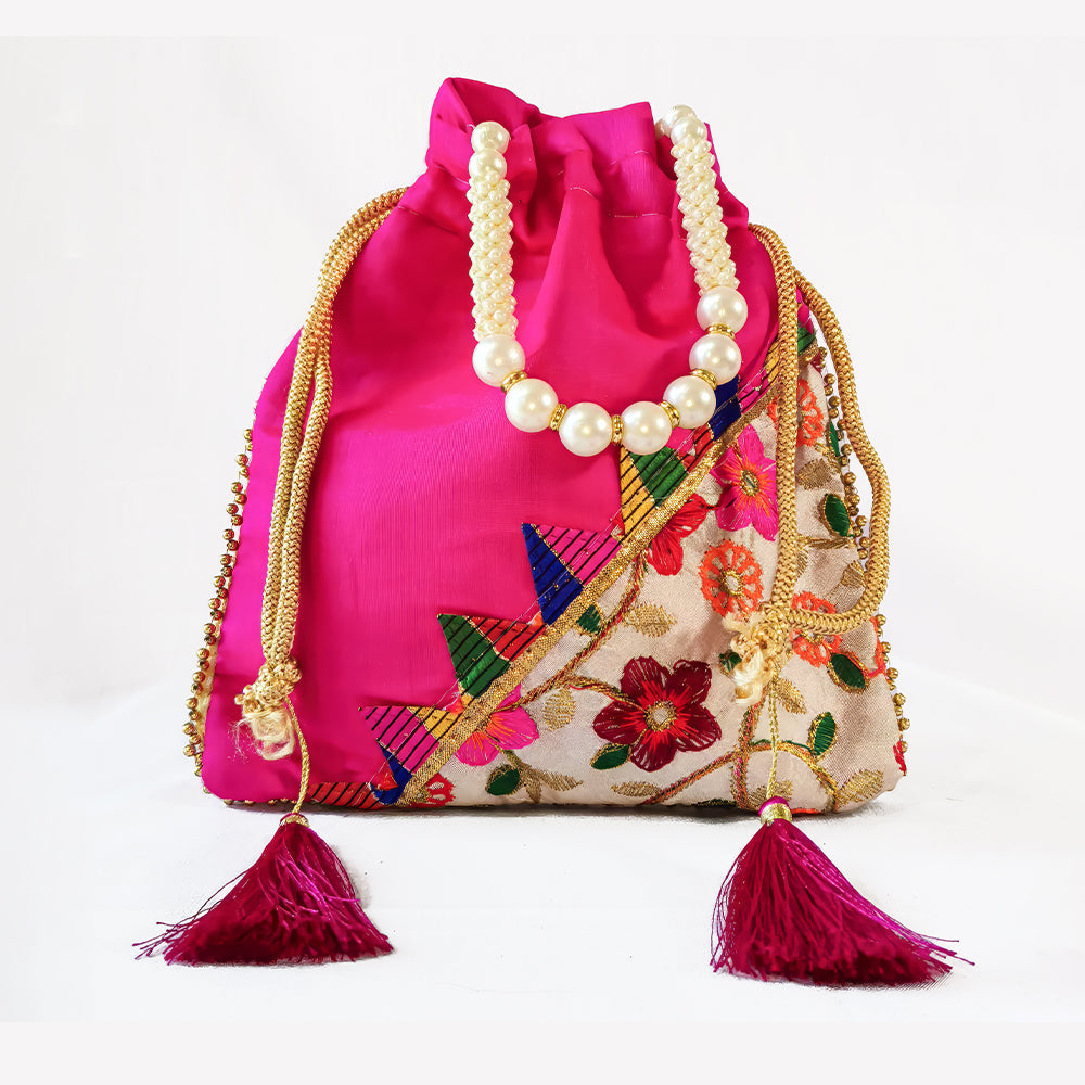 Close-up of a handcrafted wedding potli bag with intricate embroidery, pearl borders, and beaded handle.