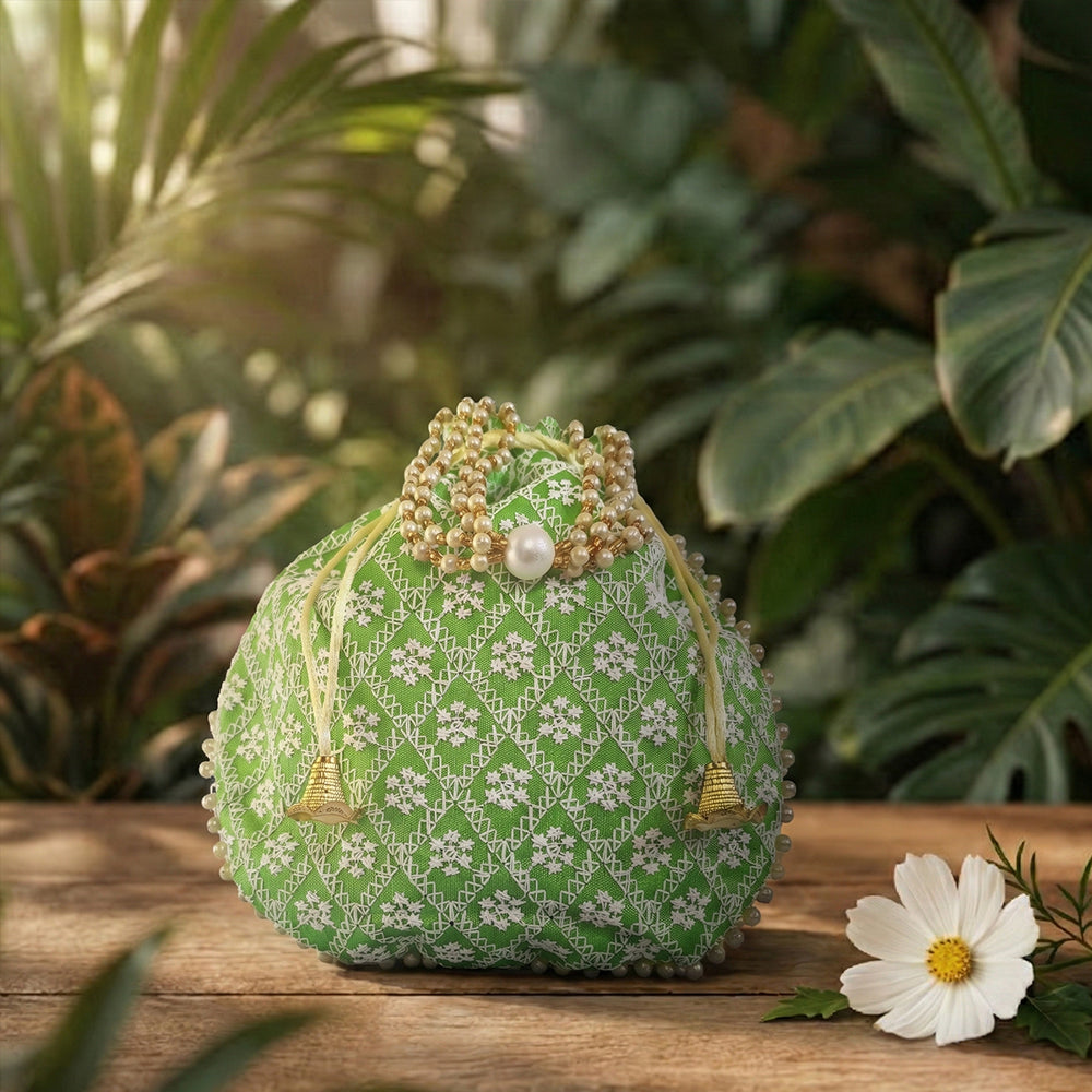 Close-up of a handcrafted wedding potli bag with intricate embroidery, pearl borders, and beaded handle.