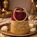 Designer silk potli bag with ornate golden embroidery and pearl handle