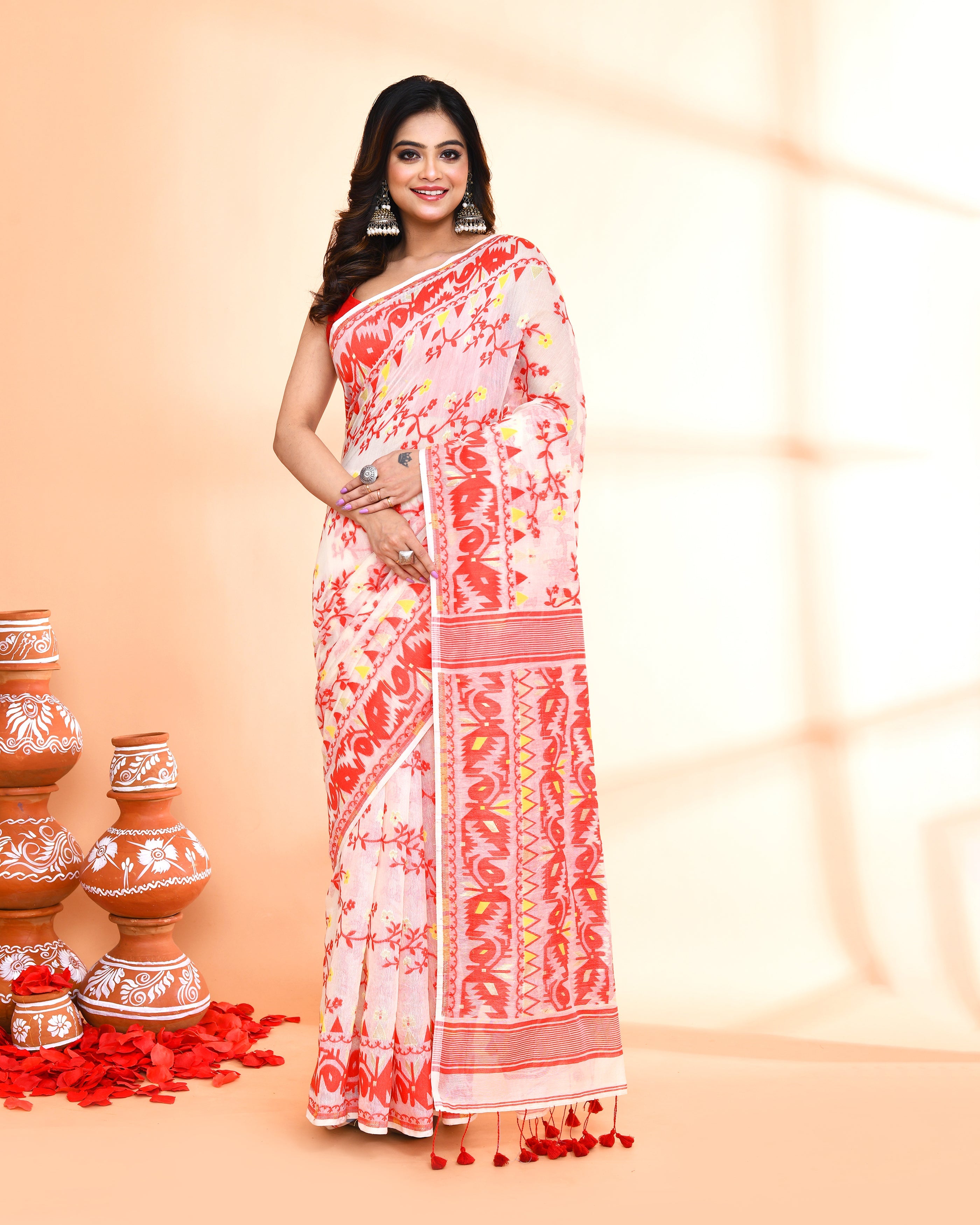 Woman wearing an elegant off-white and red cotton silk Jamdani saree with traditional patterns