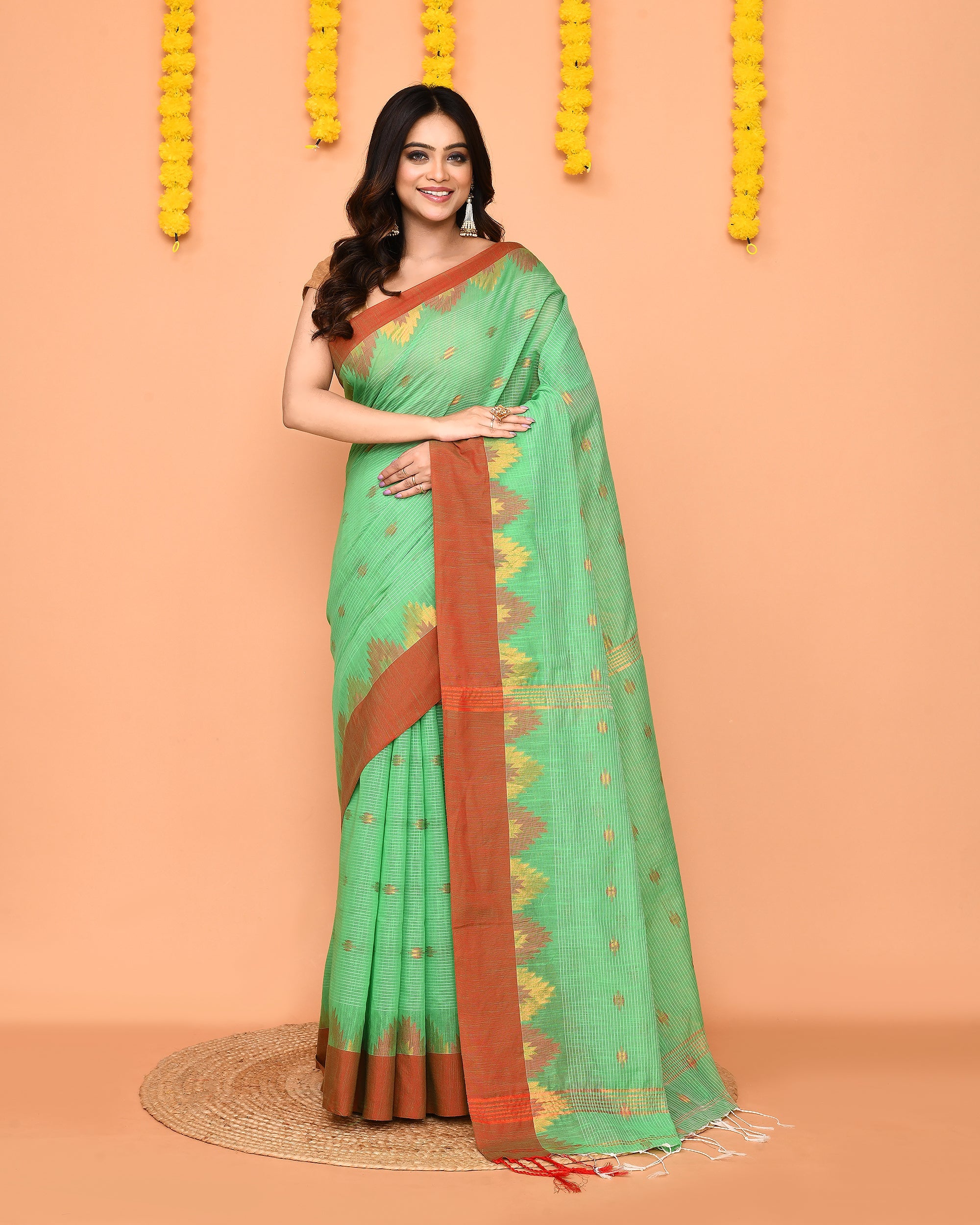 Green handloom cotton blend saree with a contrasting red temple border