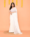 Close up of a white handloom Jamdani cotton blend saree with decorative tassels.