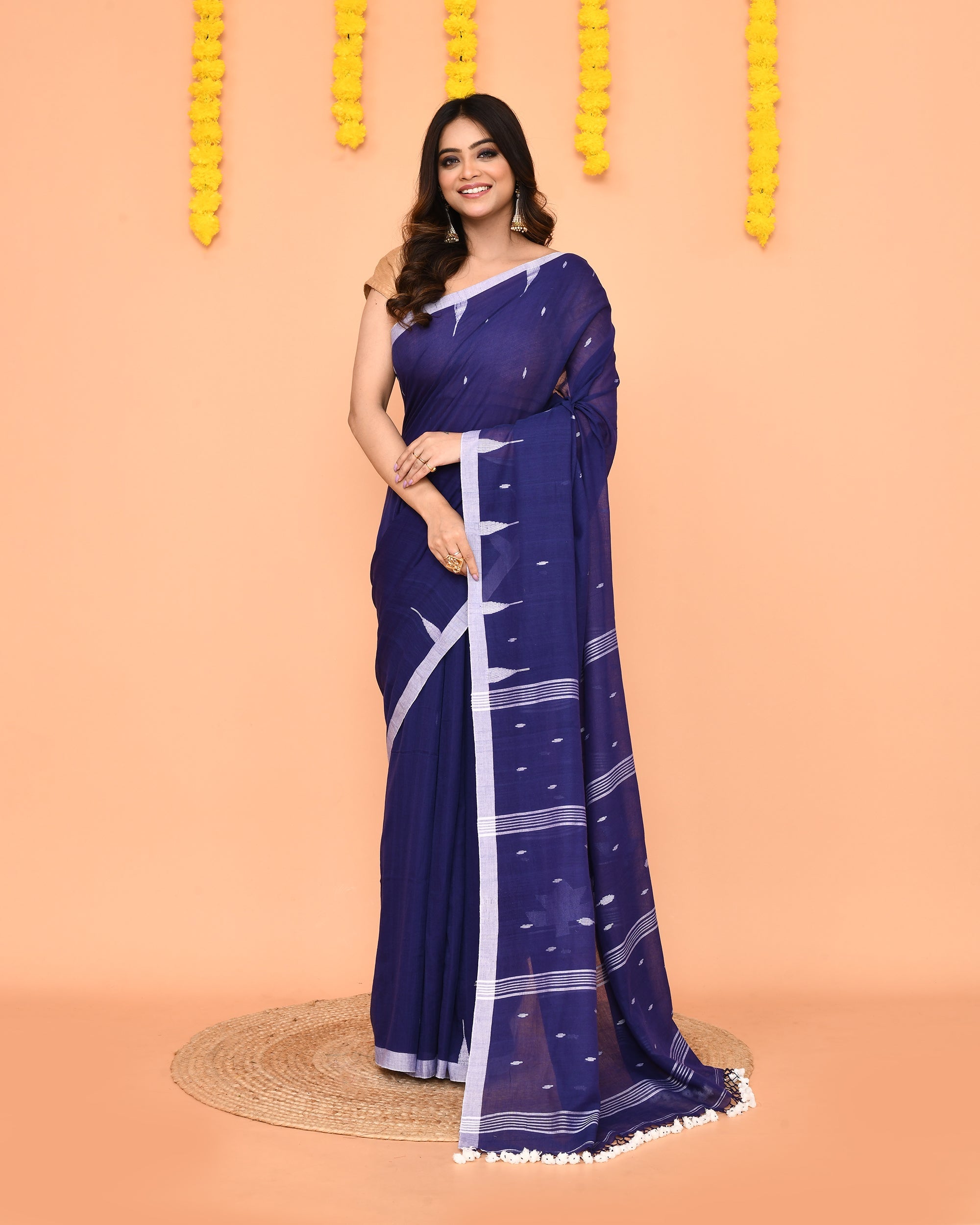 Soft blue Mul cotton Jamdani saree featuring net tassels and traditional weave.
