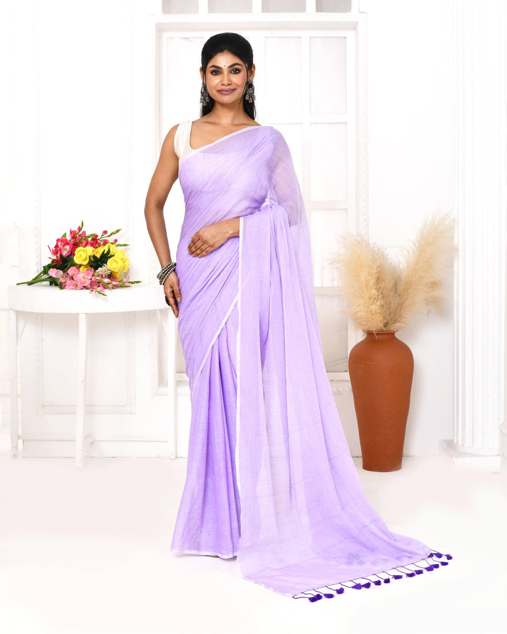 Elegant lavender mulmul cotton saree featuring intricate tassel details on the pallu.