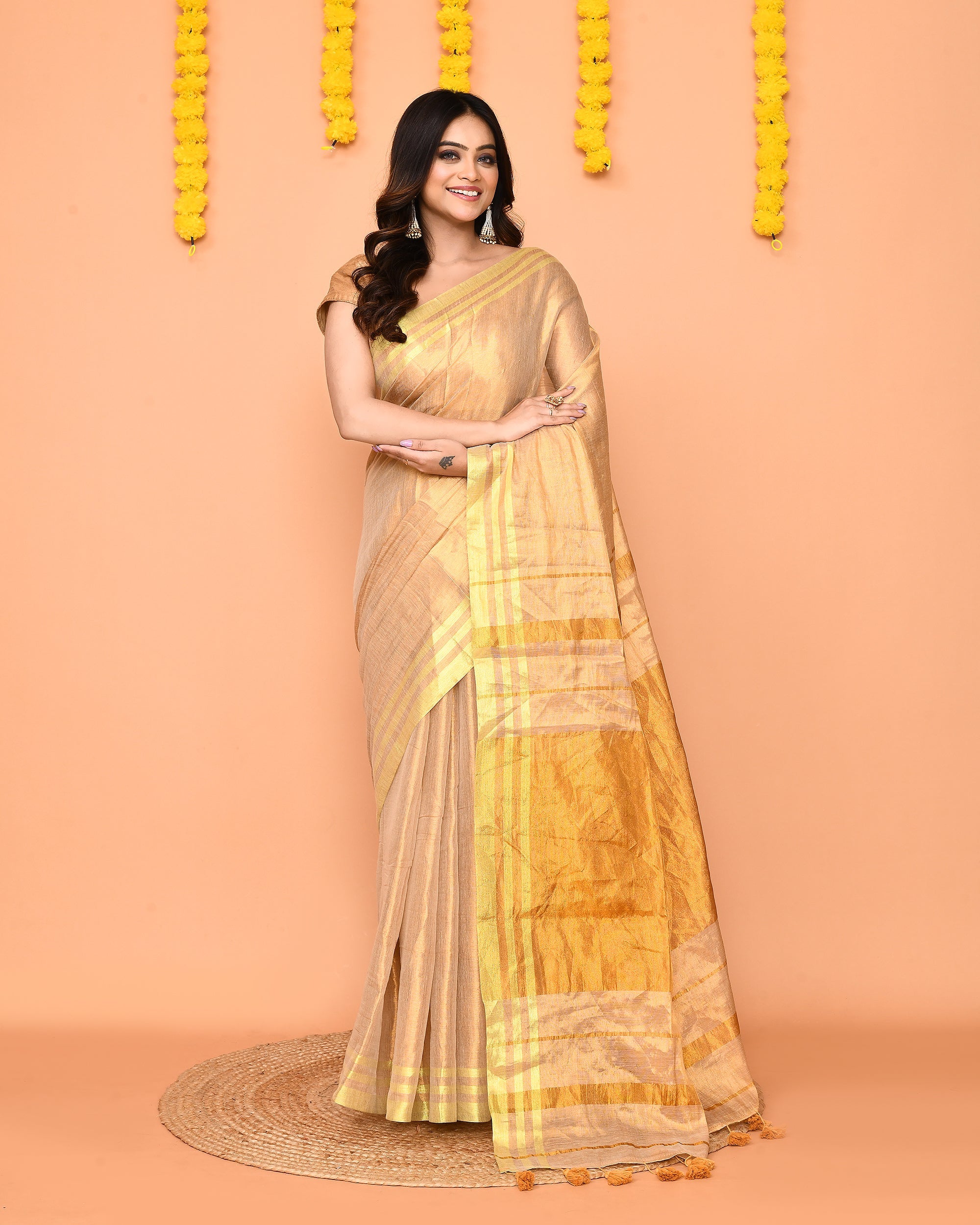 Beige handloom tissue saree with red borders and zari detailing.