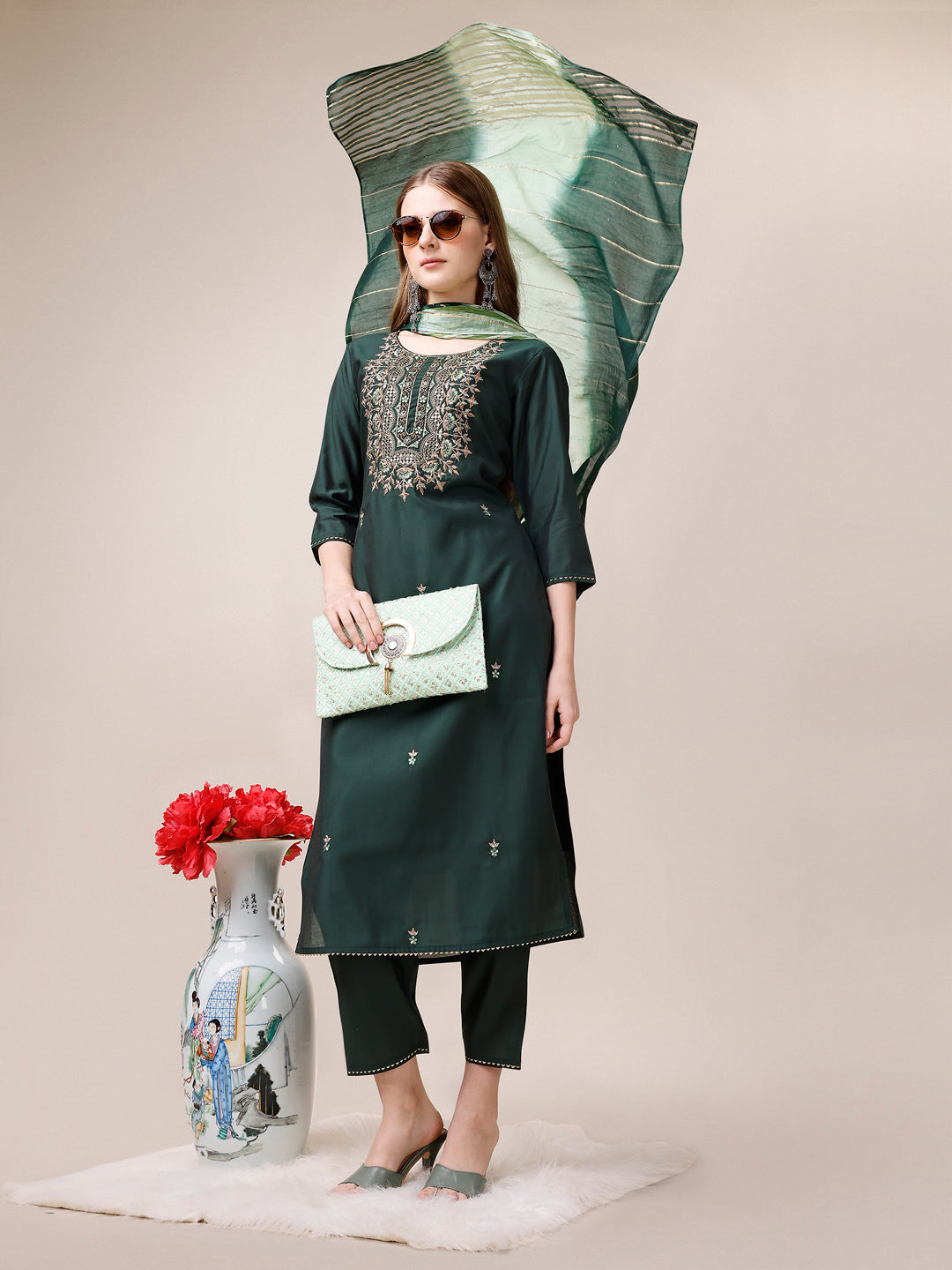 A woman wearing a vibrant multicolor embroidered kurta set with matching pants and a dupatta.