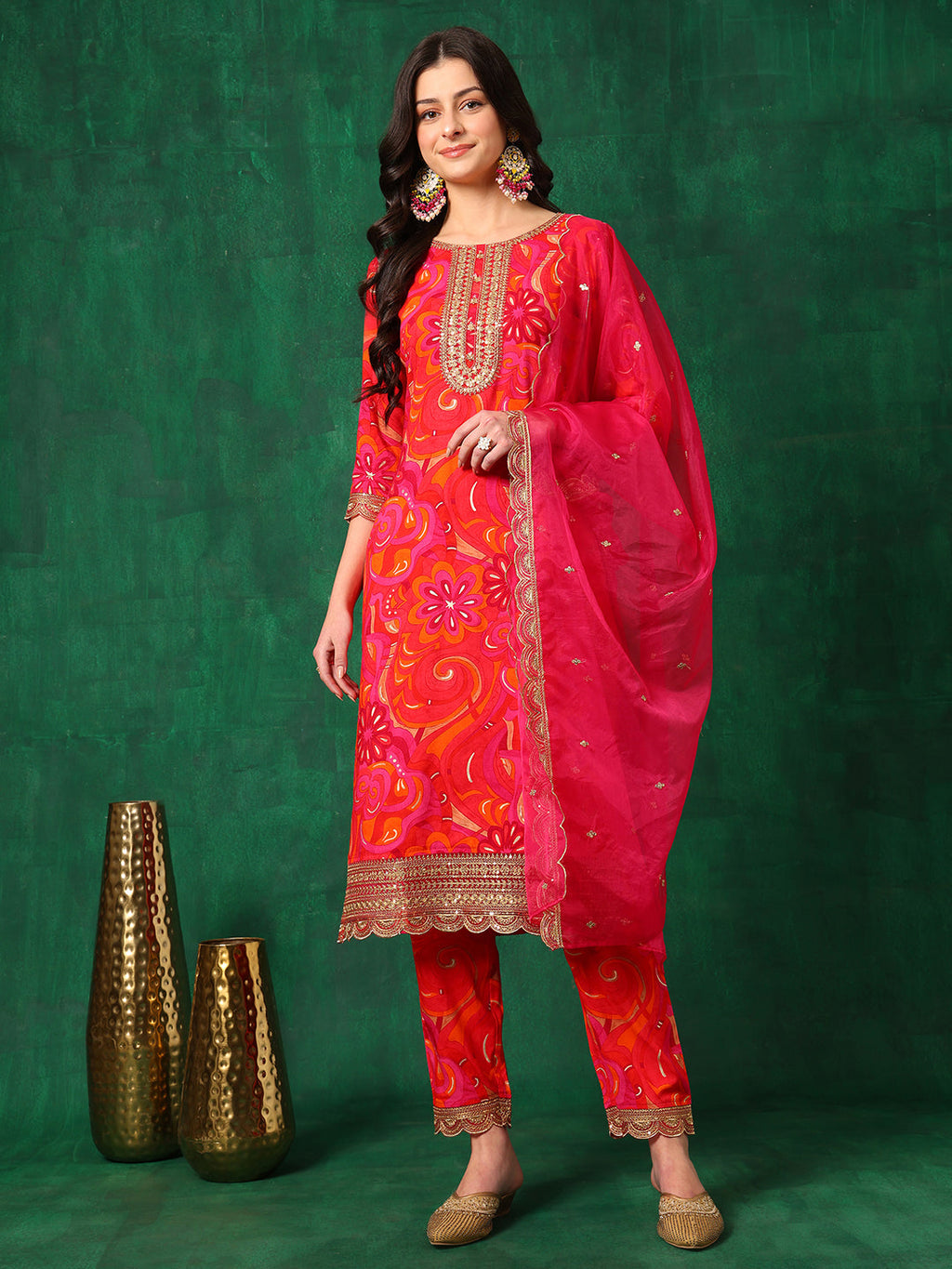 A woman wearing a pink sequined and printed kurta set with an embroidered dupatta and matching pants.