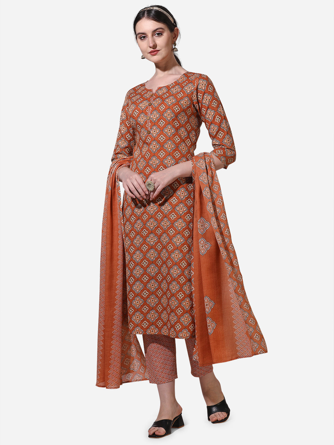Model wearing a rust-colored rayon kurta set with vibrant floral prints and a matching dupatta