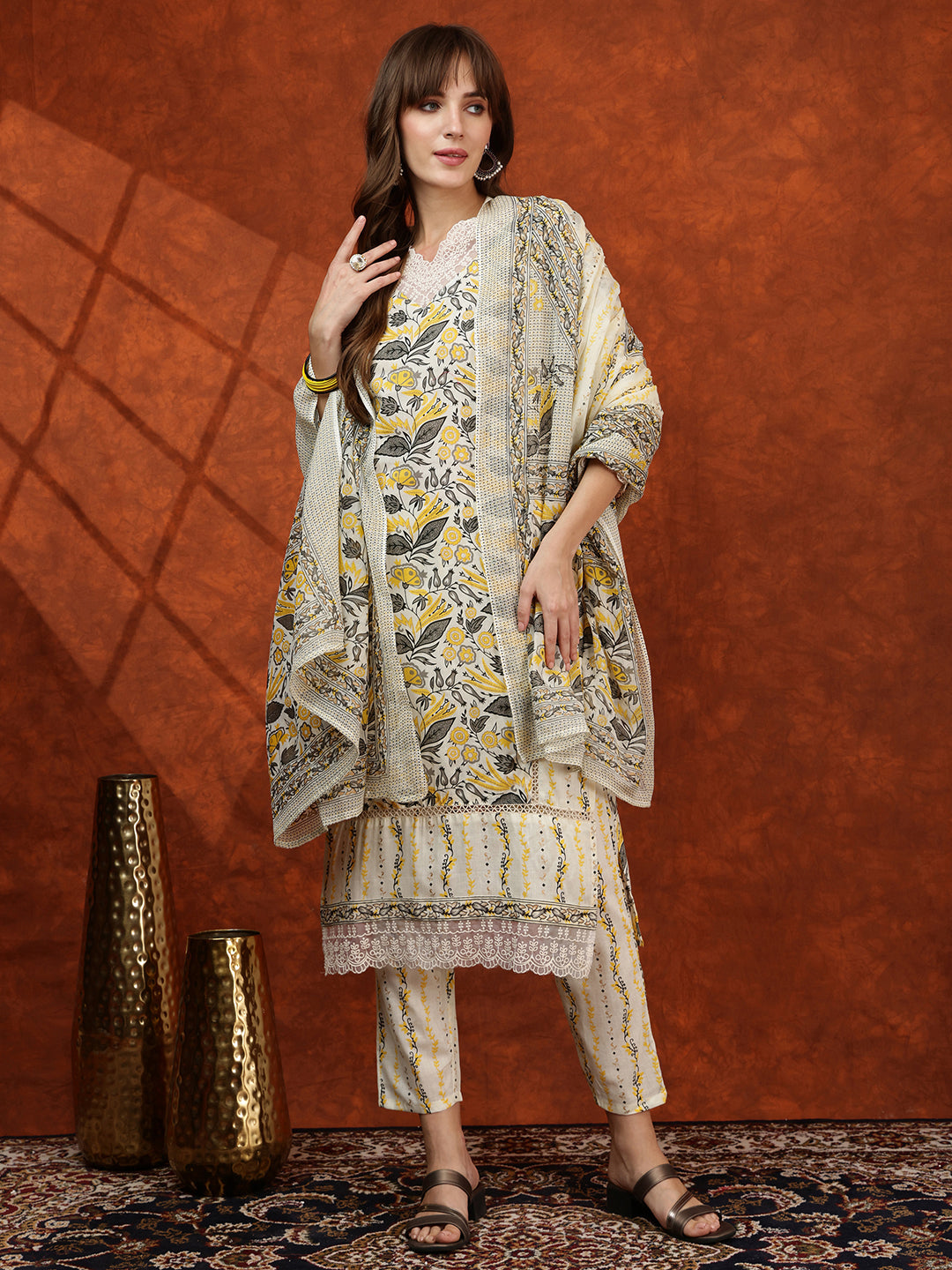 Yellow cotton printed kurta with lace detailing, matching pants, and a dupatta