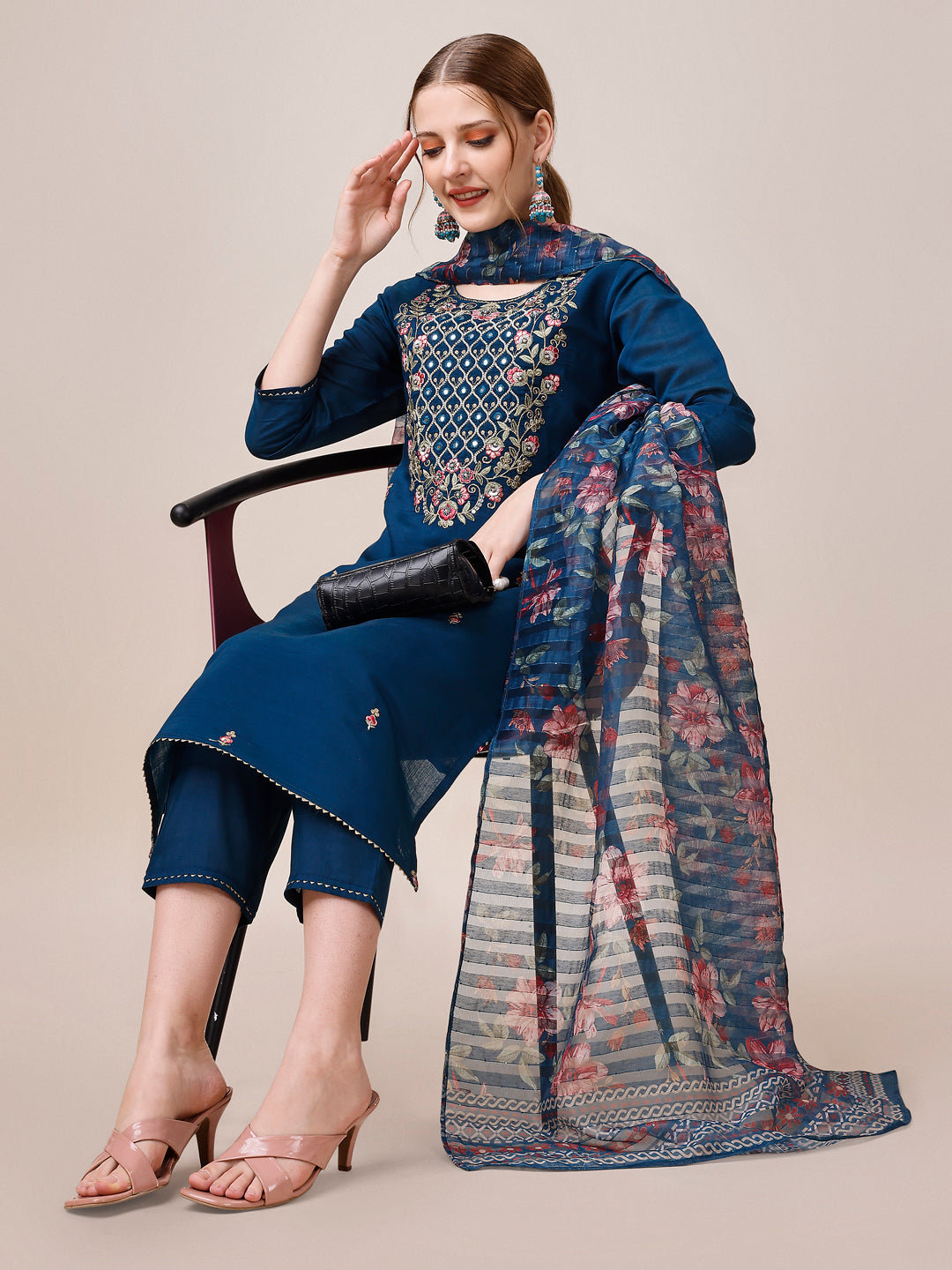 A woman wearing a vibrant multicolor hand-embroidered kurta with matching pant and dupatta set.