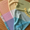 Close up of a hand-woven pastel baby blanket pattern for nursery crib styling.