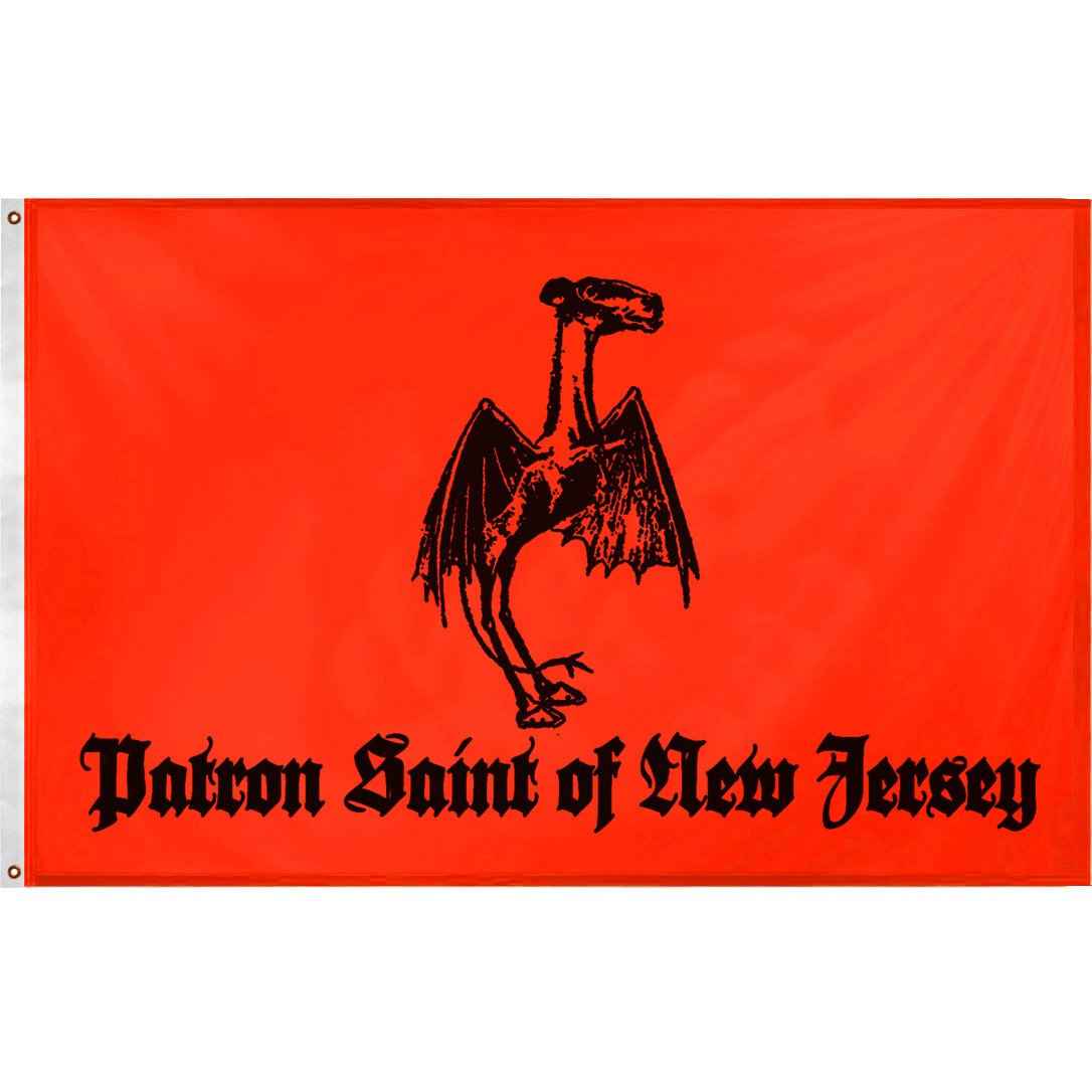 A vibrant orange and black Jersey Devil Patron Saint flag hanging on a wall as alternative home decor.