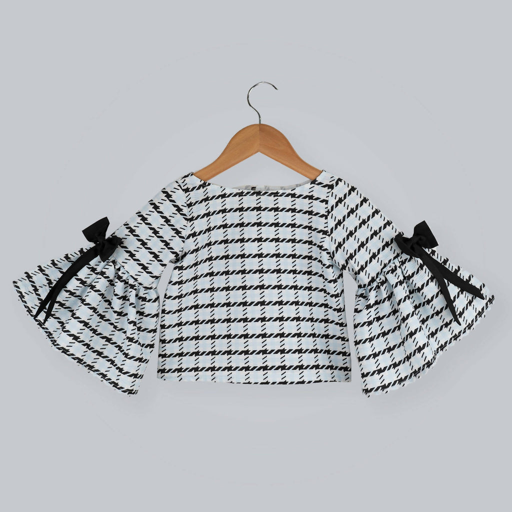 Black and white box printed top with long bell sleeves and black taffeta bow accents.