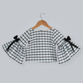 Black and white box printed top with long bell sleeves and black taffeta bow accents.