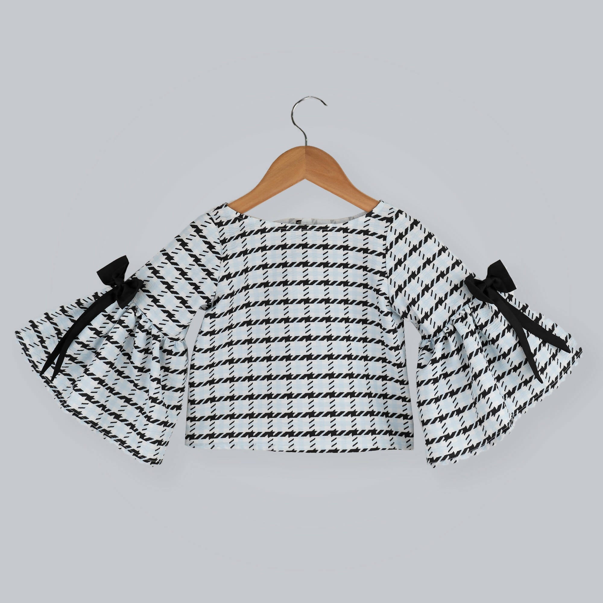 Black and white box printed top with long bell sleeves and black taffeta bow accents.