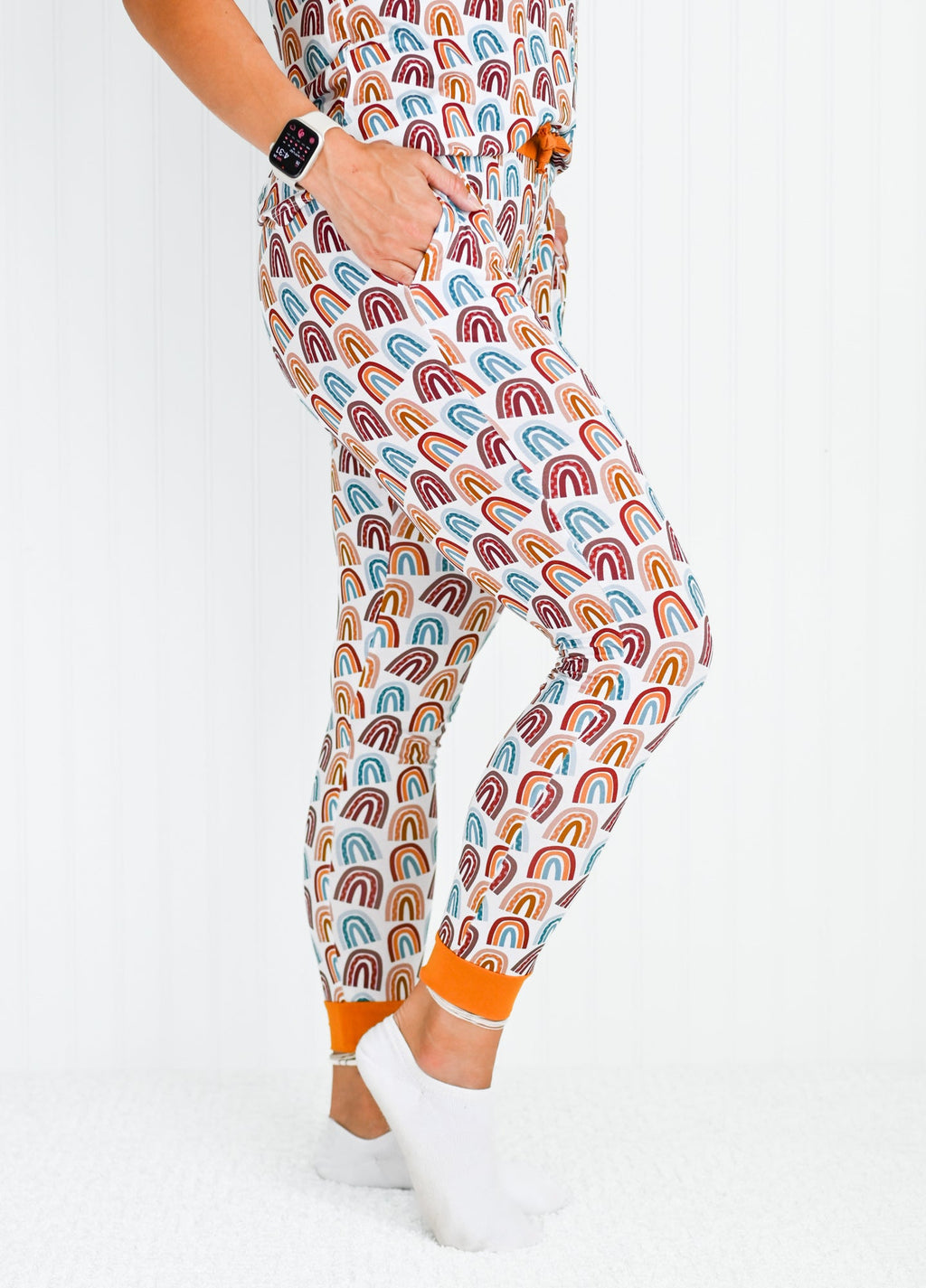Close up view of neutral rainbow patterned bamboo jogger pants with orange drawstring waist