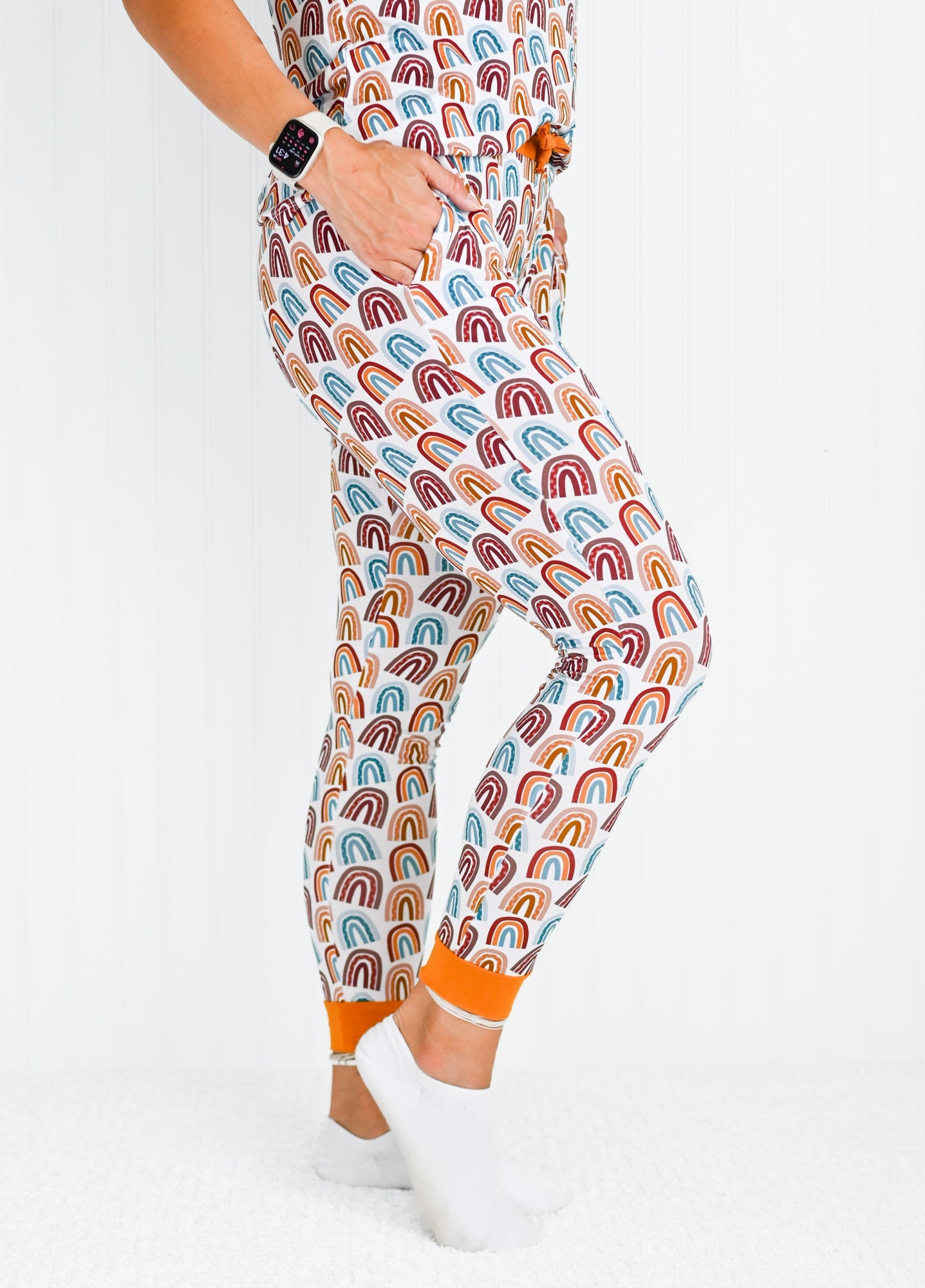 Close up view of neutral rainbow patterned bamboo jogger pants with orange drawstring waist