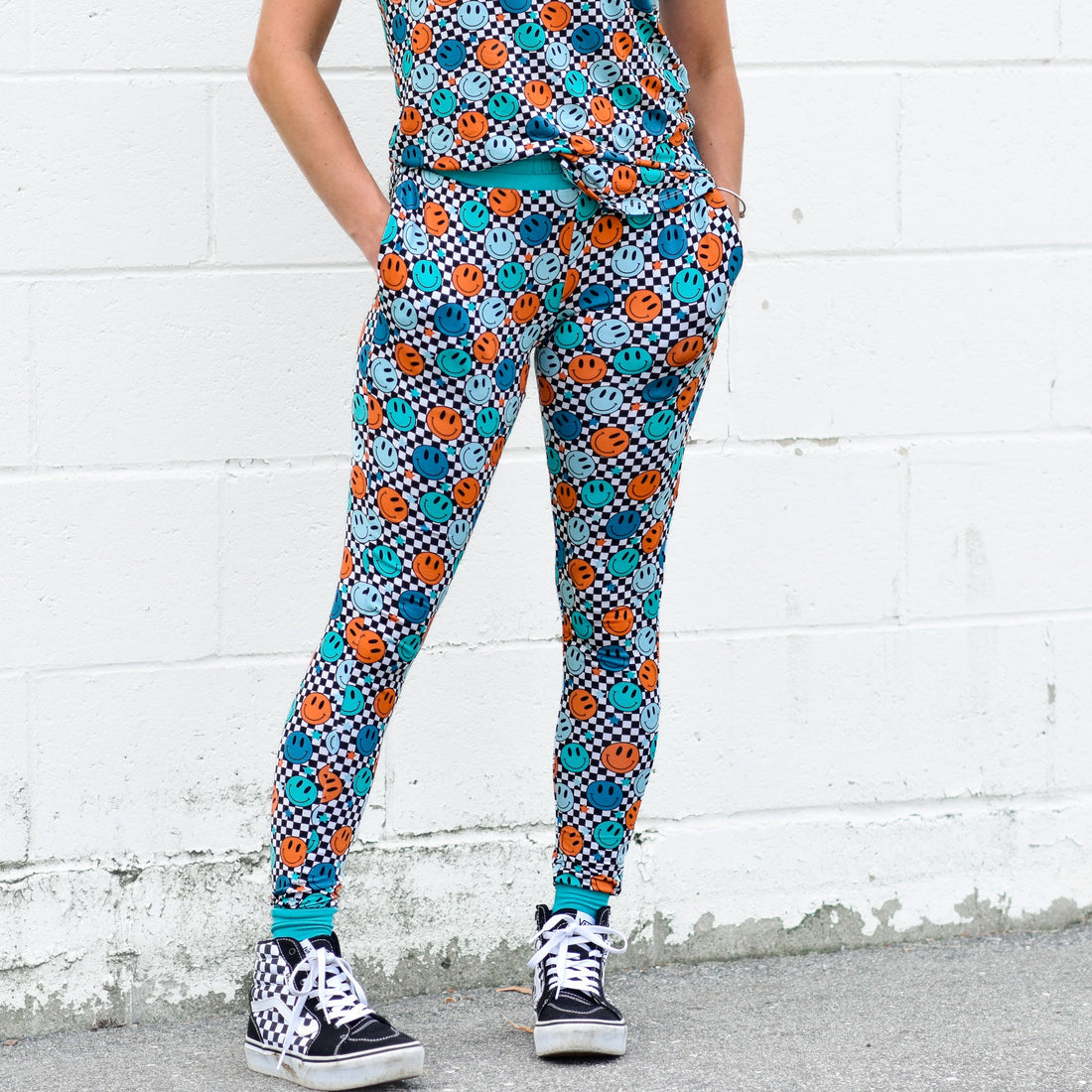 Woman wearing blue and orange smiley face checkerboard print bamboo joggers with side pockets