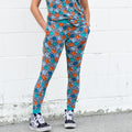 Woman wearing blue and orange smiley face checkerboard print bamboo joggers with side pockets