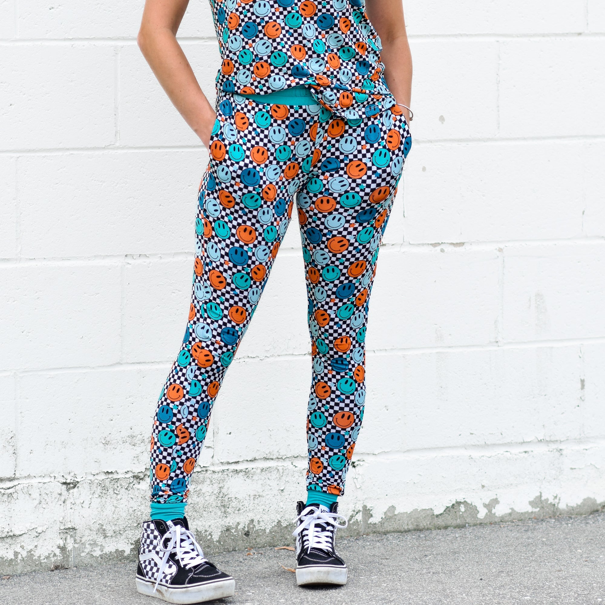 Woman wearing blue and orange smiley face checkerboard print bamboo joggers with side pockets