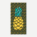 A rectangular beach towel featuring a large central pineapple design with a pattern of smaller pineapples on a black background in yellow and teal colors.