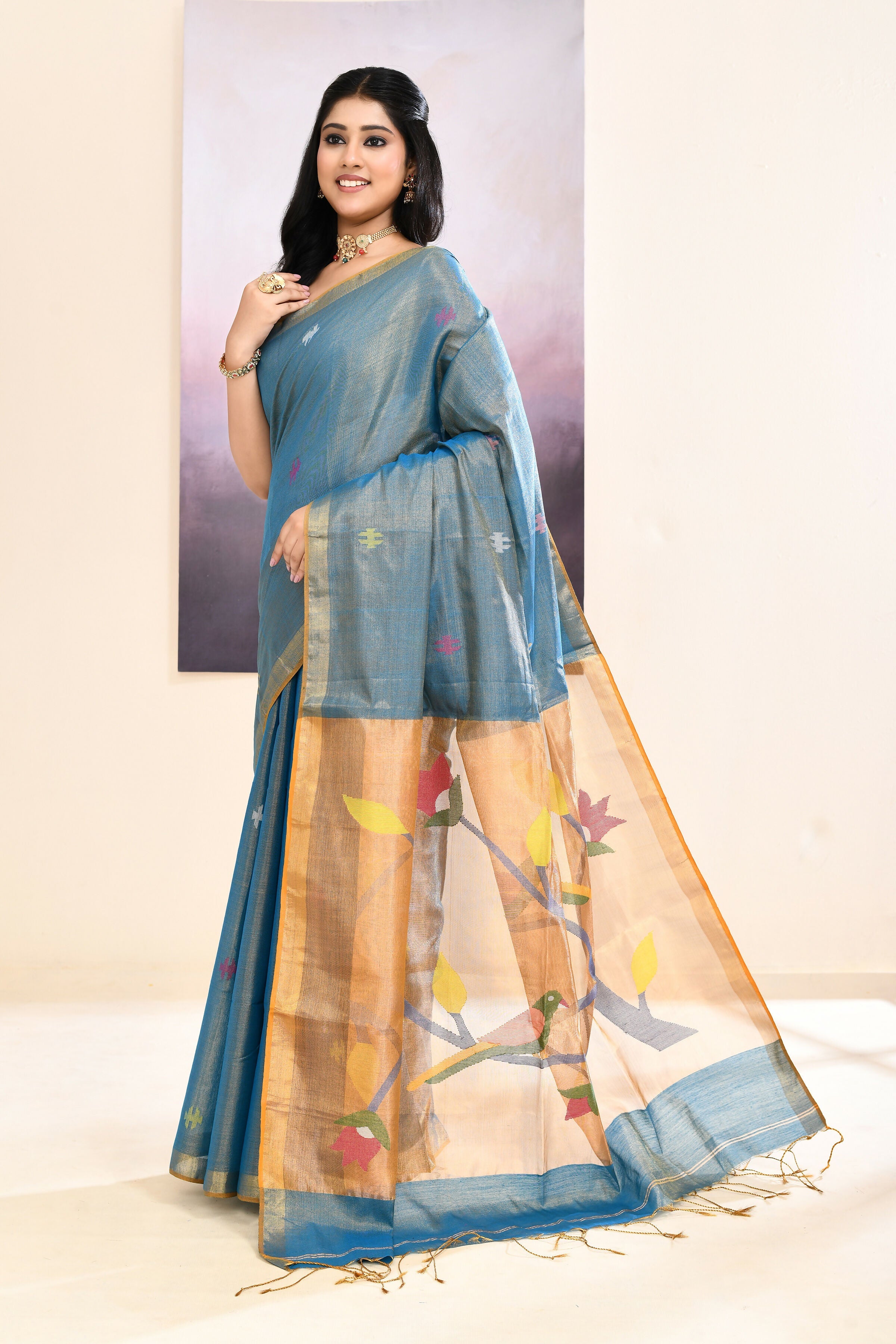 Sky blue tissue jamdani saree with intricate embellishments draped elegantly.