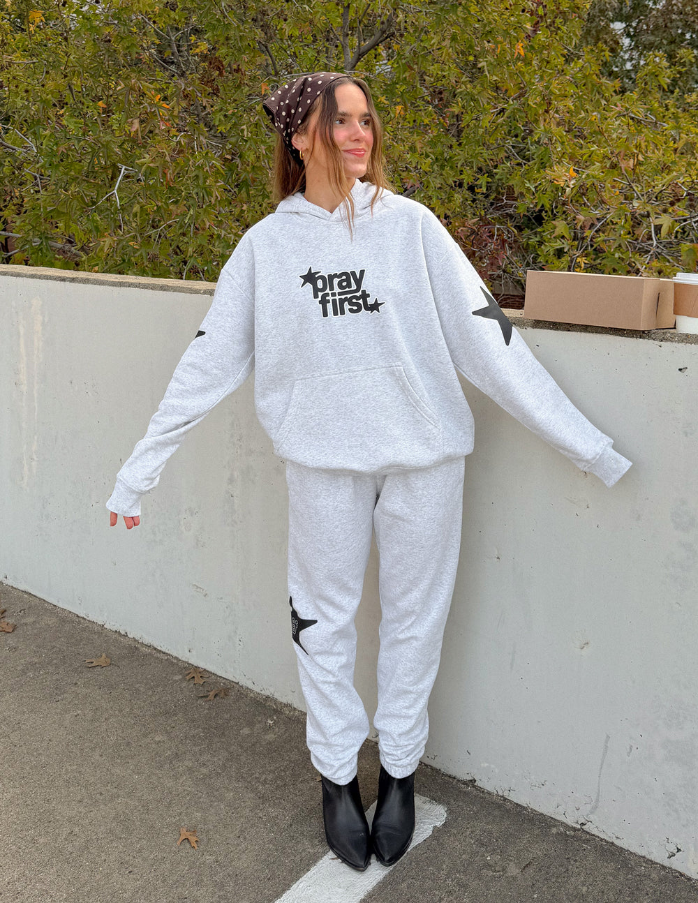 Grey and black unisex hoodie featuring Pray First text