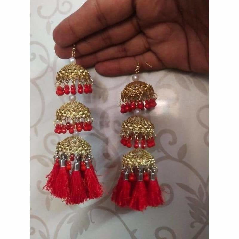 Gold color jhumka earrings featuring red pearls and silk thread detailing