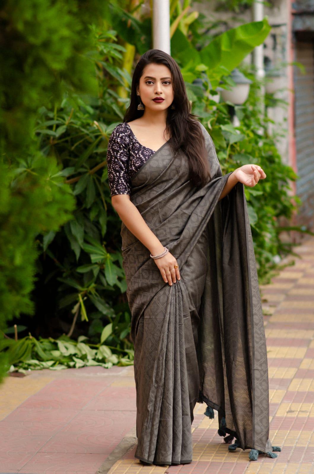 Grey jute silk jacquard saree with woven details and cotton tassels on the pallu.