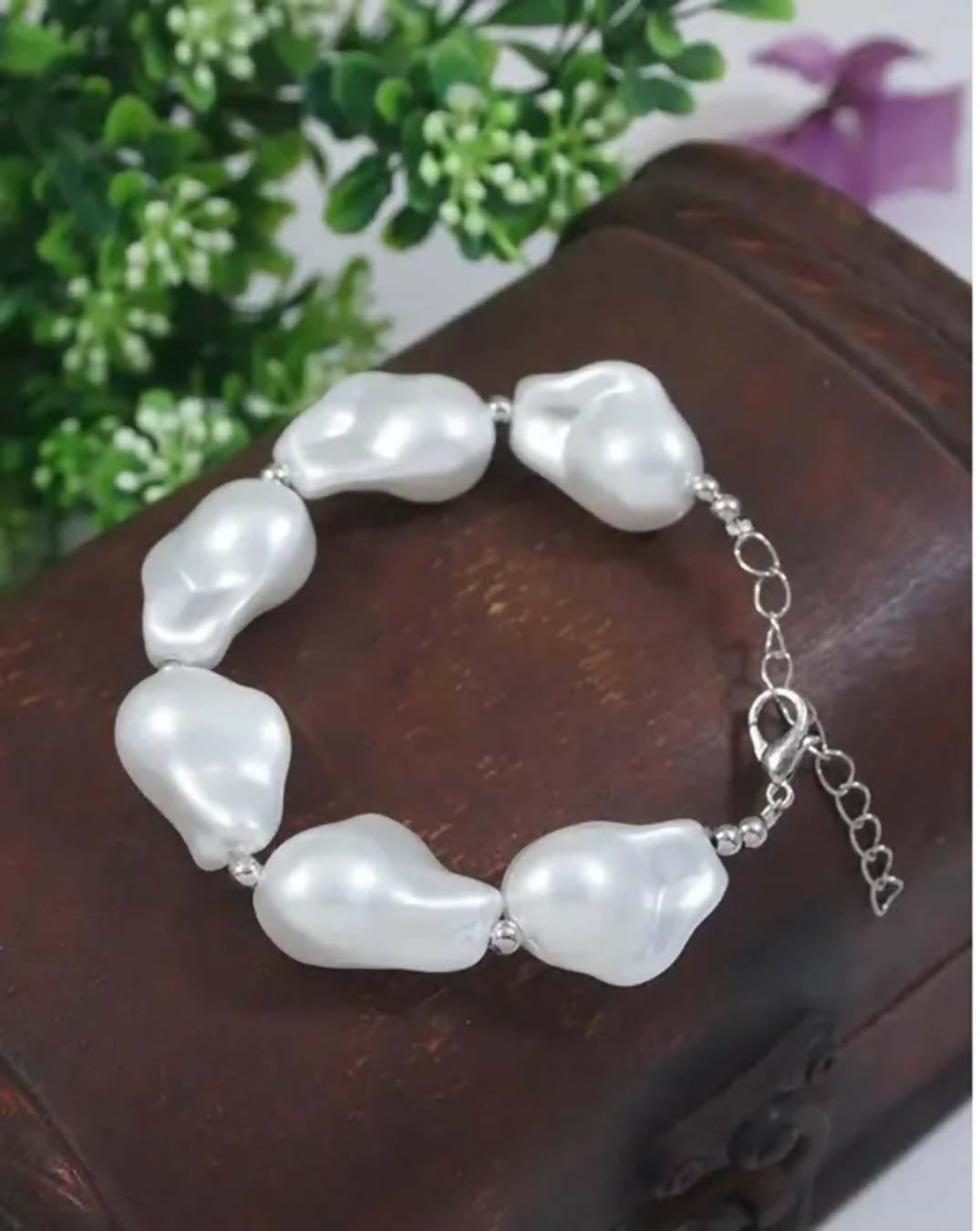 Handmade bohemian style bracelet featuring iridescent white baroque pearls and metallic silver accents