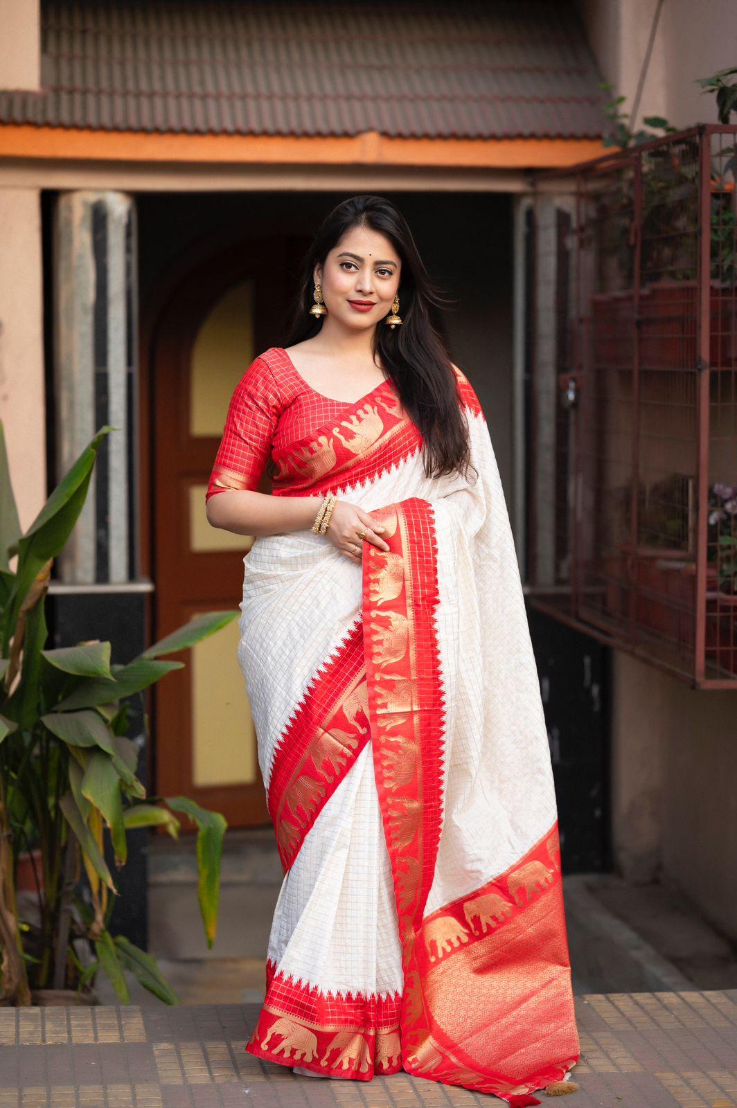Red silk saree with zari woven chex, elephant border, and rich pallu.