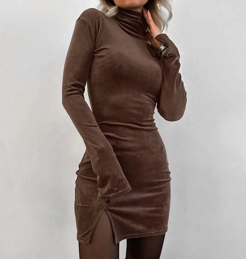 A woman wearing a brown long-sleeve velvet turtleneck mini dress with a side slit detail.