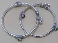 A pair of traditional Rajasthani Hasli design anklets for girls with silver, red, and green accents.