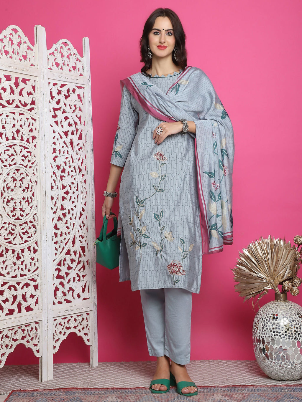 Woman wearing a grey muslin floral print kurta set with jari and crystal embroidery details