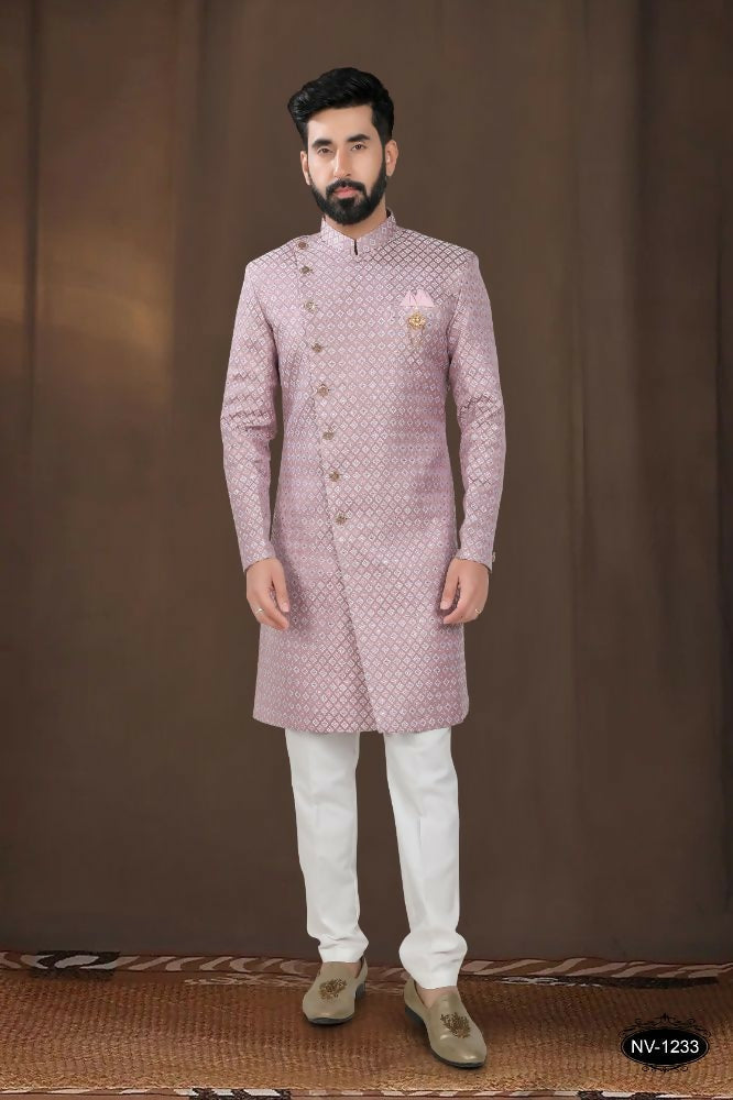 A toddler wearing a pink woven jacquard kurta with white pyjamas for a festive occasion