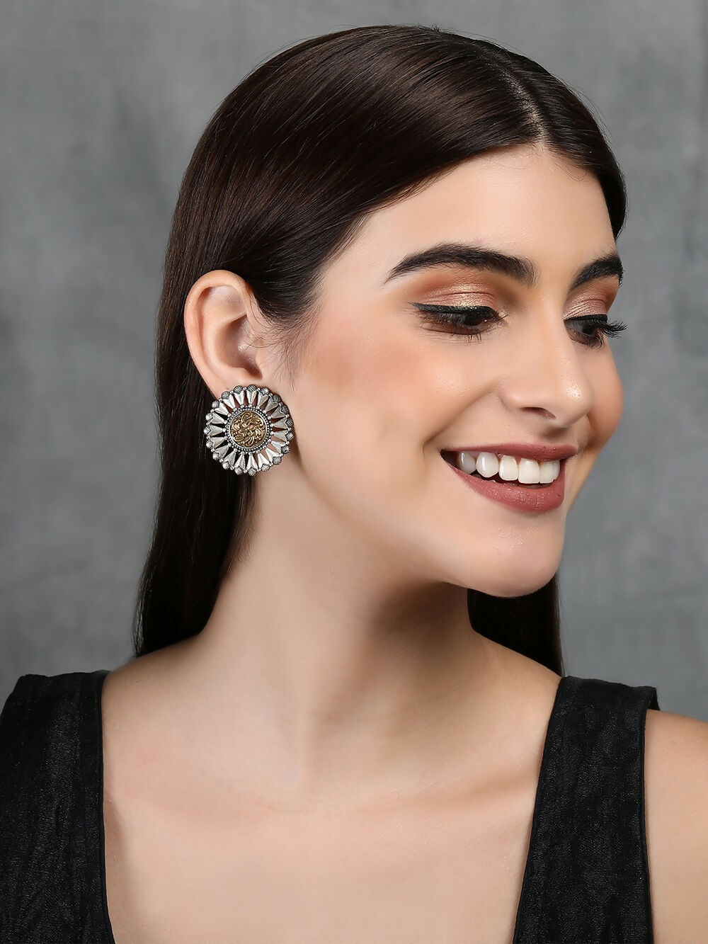 Round dual tone brass earrings with intricate patterns and embedded stones
