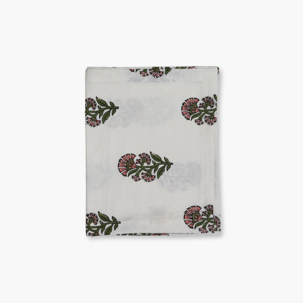 Begum hand-printed linen table runner in pink and green floral motif on a white background