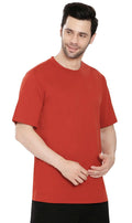 A man wearing a heavyweight relaxed fit crew neck cotton blend t-shirt in a solid color